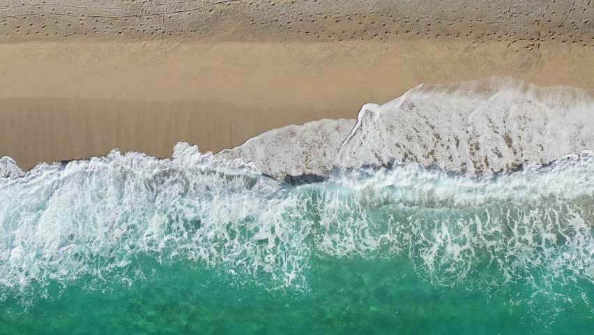 Scenery sea waves crashing on the beach. Turquoise sea and white waves of Turkiye. Aerial footage