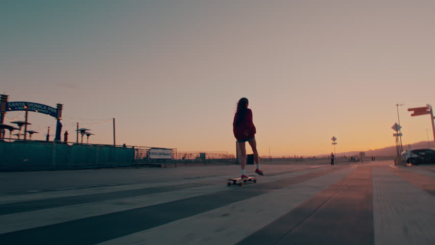 Female longboarder riding a board at sunset Royalty-Free Stock Footage #1110355389