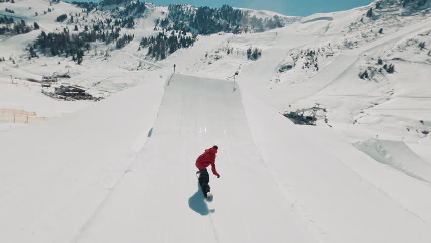 FPV drone shot of a snowboarder flying through the air