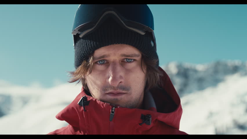 Snowboarder putting his ski goggles on