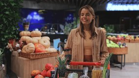 Young fun customer woman wearing casual clothes choosing fruit vegetable shopping at supermaket store grocery shop with trolley cart buy products inside hypermarket. Purchasing food gastronomy concept - Powered by Shutterstock - Get 15% off with code: PIKWIZARD15