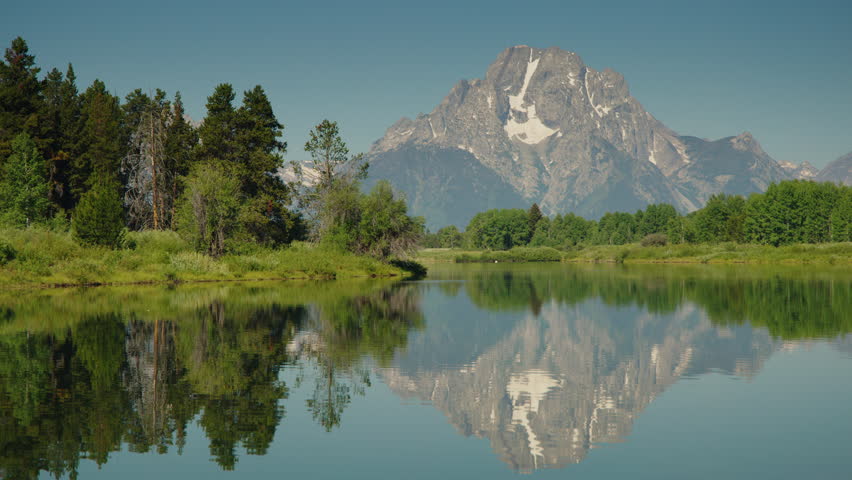 Reflection of mountain range in scenic snake river, grand teton national park, wyoming, united states