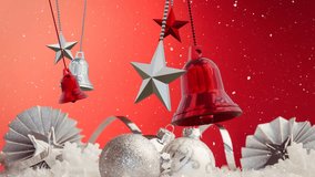 Animation of christmas baubles over snow falling on red background. Christmas, tradition and celebration concept digitally generated video.