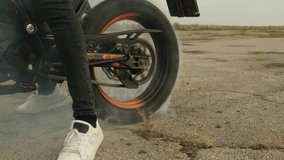 Wheel of a drifting racing motorcycle. Tire burnout, smoke coming out from under the wheel, due to tire rubbing against asphalt. Slow motion - Powered by Shutterstock - Get 15% off with code: PIKWIZARD15