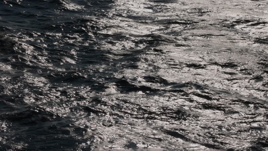 Small waves in dark ocean water with bright morning light in slow motion Royalty-Free Stock Footage #1110371565