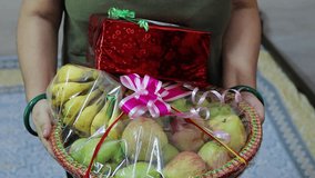 fruit gift wrap filled with different fruits and gift pack holding at hand from flat angle - Powered by Shutterstock - Get 15% off with code: PIKWIZARD15
