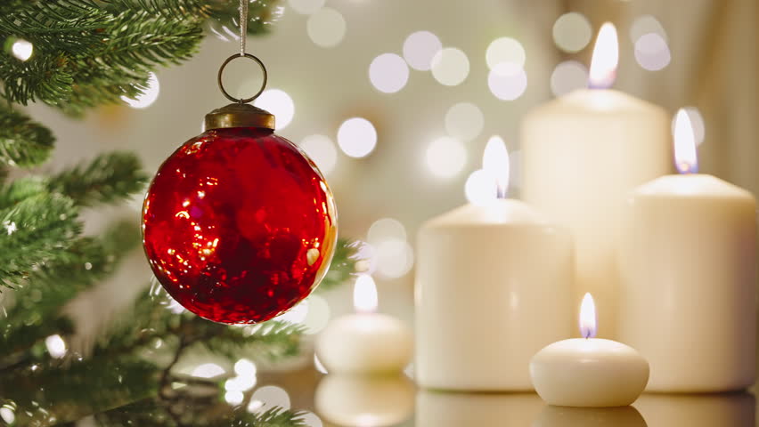 Christmas concept red glass ball rotate on branch Christmas tree close-up burning candles bokeh flickering light bulbs garlands. Happy New Year. Noel. Decorated Christmas tree. Winter holidays family Royalty-Free Stock Footage #1110378793