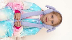 Funny girl with bunny ears. Christmas bunny in kigurumi pajamas. Funny wiggling ears headband. Bunny costume for Easter. Happy easter. Baby in Barbie style. Vertical video