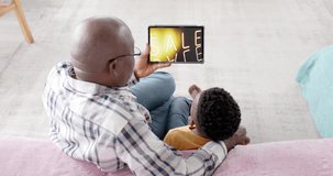 African american grandfather and grandson using tablet, shopping online during sale, slow motion. Retail business, sale, communication and digital interface digitally generated video.