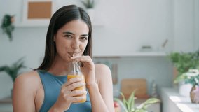 Video of beautiful sporty woman drinking healthy orange juice while standing in the kitchen at home - Powered by Shutterstock - Get 15% off with code: PIKWIZARD15