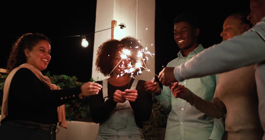 Happy african family hugging each other and celebrating new year's eve with firework sparkler Royalty-Free Stock Footage #1110384917