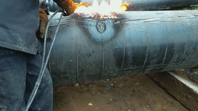 Video slow motion. Acetylene welding cuts a metal pipe in the open air. Metal cutting. A real non-staged scene. Industrial background.