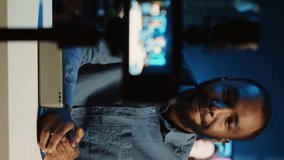 Vertical video African american internet star doing technology review of wireless portable speaker for online platforms channel. BIPOC influencer presenting music playing device to his fanbase - Powered by Shutterstock - Get 15% off with code: PIKWIZARD15