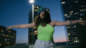 Bottom view cute girl having fun at sunset disco. Closeup smiling woman dancing for camera outdoors at night skyscrapers on background. Cheerful female person moving hands to beat of music at rooftop - Powered by Shutterstock - Get 15% off with code: PIKWIZARD15