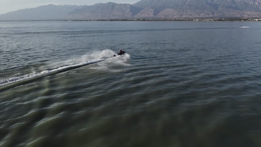 Waverunner Rider on Utah Lake with Timpanogos Mountain Backdrop, Aerial Royalty-Free Stock Footage #1110393299