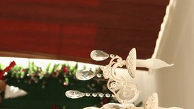 Vertical video, smooth camera movement, close-up of a chandelier against a background of Christmas bokeh.
