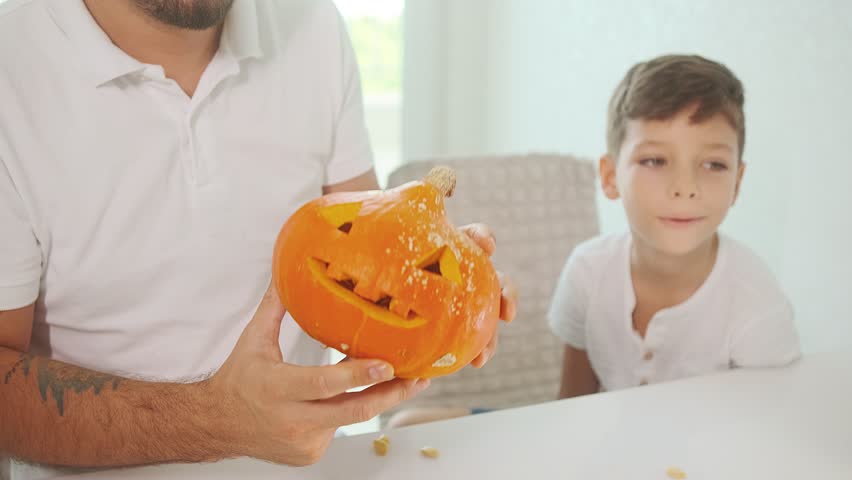 Dad and son peel the pumpkin from the seeds, cut out jack, halloween preparation jack-o