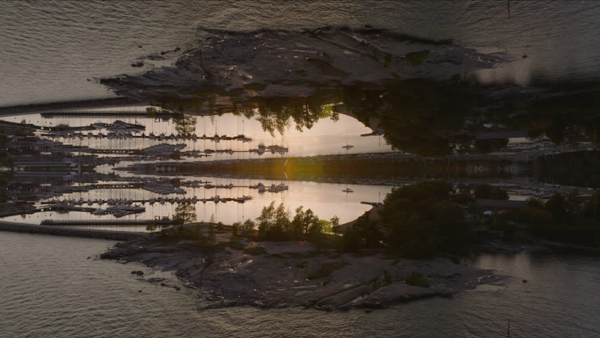 Forwards fly above marina at sunset. Yachts and sailboats moored at piers. Helsinki, Finland. Abstract computer effect digital composed footage