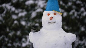Comical portrait of snowman with carrot eyes, nose, and bucket hat perched on its head during winter season and snowfall. Wintertime, christmas eve, cold weather, new yaer - Powered by Shutterstock - Get 15% off with code: PIKWIZARD15