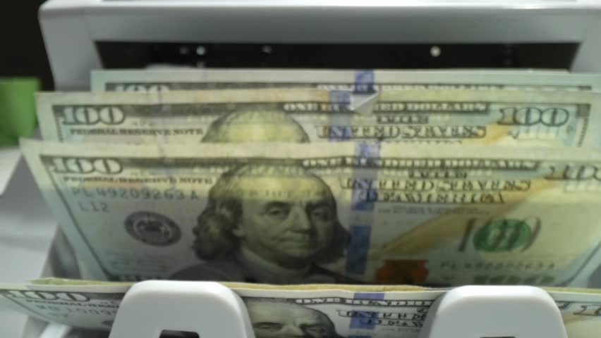Cash money inside running banknotes counter. Banking and financial concept. Electronic money counter with new hundred dollars banknotes. Counter machine is counting 100 dollars banknotes.