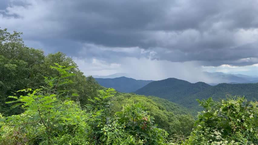 Horizontal Smoky Mountain Landscape Video with Blue Mountains, Green Trees and Dark Clouds - Camera Panning Left to Right