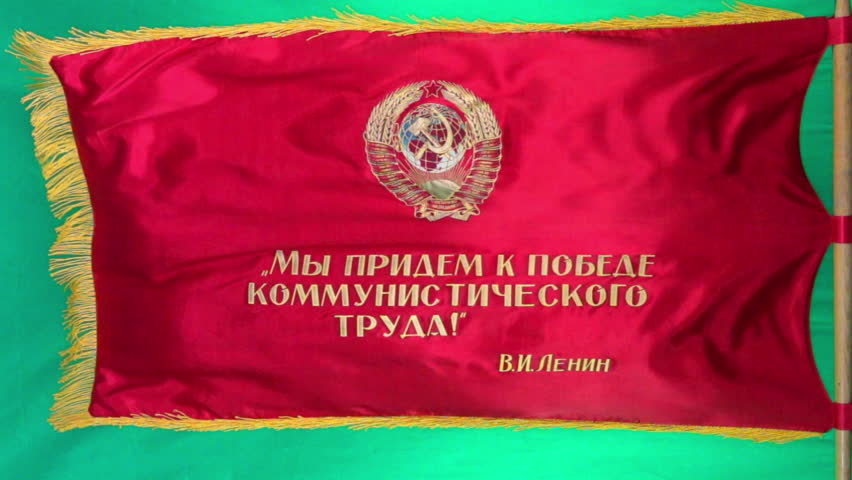 A Soviet parade flag displaying a hammer and sickle emblem flies in slow motion against a green screen background. Royalty-Free Stock Footage #1110425557