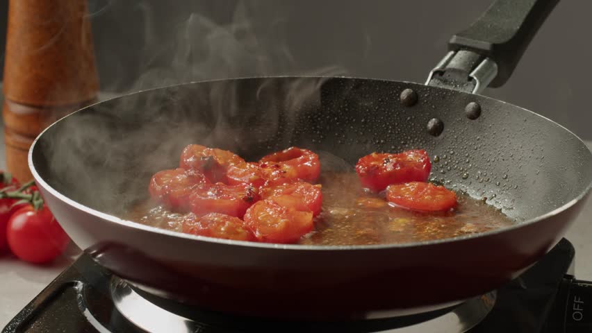Fresh cherry tomatoes in a frying pan with olive oil and spices. Cooking tomato sauce. Traditional Italian Mexican Asian dish. High quality studio shot for cafe, restaurant close up. Royalty-Free Stock Footage #1110430665
