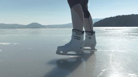 SLOW MOTION, LENS FLARE: Close up view of a lady ice skating on big naturally frozen lake on a sunny day. She is gliding across icy surface with her white skates. Outdoor activity for cold winter days - Powered by Shutterstock - Get 15% off with code: PIKWIZARD15