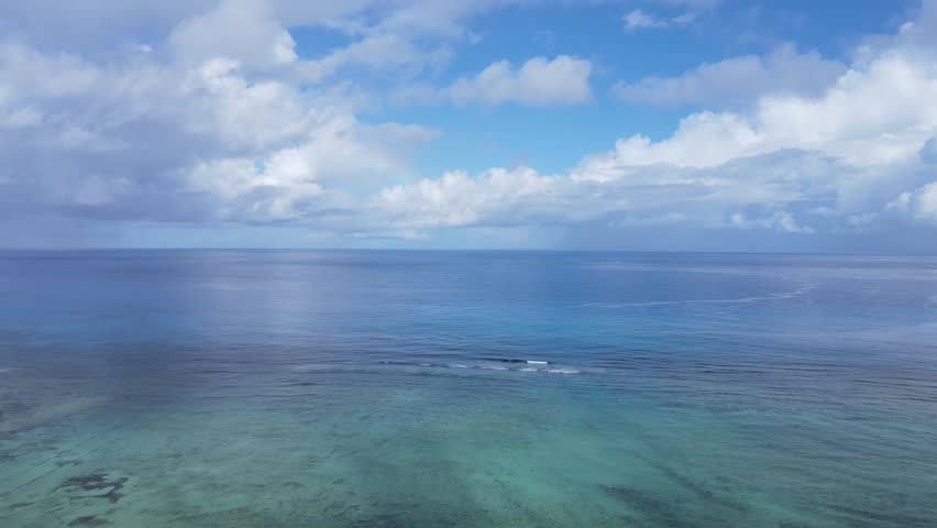 Seaside Landscape Unfolding Beneath the Blue Sky and White Clouds