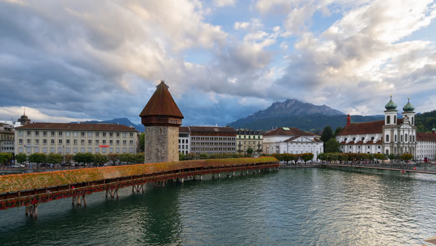 Lucern, Switzerland with the Chapel Bridge over the River Reuss with Mt. Pilatus in the distance at dusk.