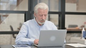 Old Businessman Chatting Online on Laptop while Sitting in Office