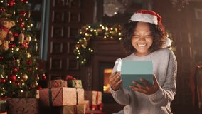Happy amazed woman opening Xmas gift box sitting in decorated traditional living room near fireplace Christmas tree. Present, surprise in winter holidays. New Year time, Christmas spirit concept. - Powered by Shutterstock - Get 15% off with code: PIKWIZARD15