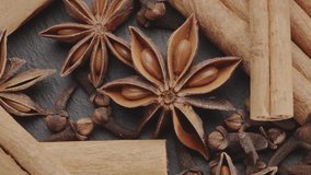 Lots of three spices for mulled wine – star anise, cinnamon and clove slowly scroll clockwise, macro video footage. A great background for your projects.