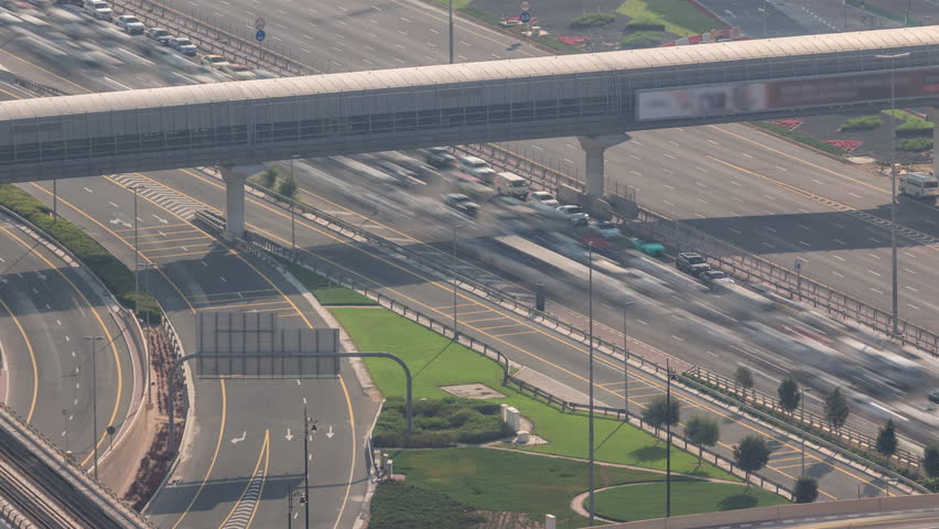 Aerial view from above to a busy road intersection in Dubai downtown timelapse. Colorful cars and trucks driving in both directions on sheikh zayed road. Traffic jam at the evening rush hour Royalty-Free Stock Footage #1110449905