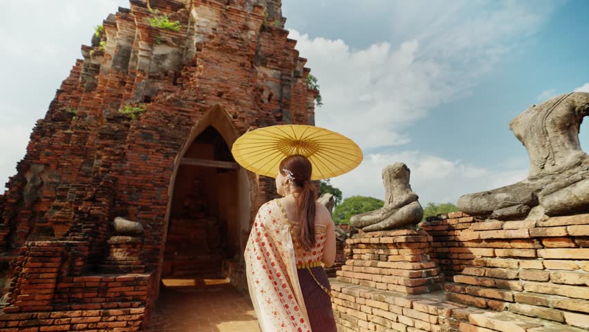 Beautiful Asian woman in Thai traditional costume with ancient pagoda at Wat Chai Wattanaram Ayutthaya, Thailand. Old pagoda the famous landmark in Ayutthaya, Thailand