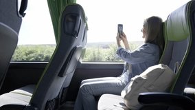 A blonde woman is filming on a smartphone in a tourist bus, sitting and looking out the window - Powered by Shutterstock - Get 15% off with code: PIKWIZARD15