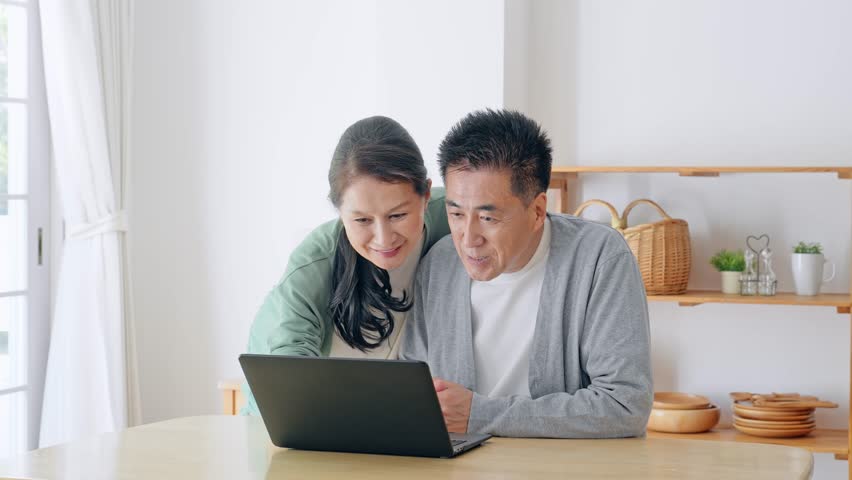Elderly couple waving at a computer. Video calling. Royalty-Free Stock Footage #1110457405
