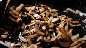 Mushrooms are frying with onions in frying pan, stock footage 4k video