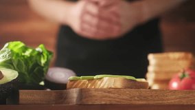 Sandwich with grilled toast, fried egg, cheese, tomatoes, lettuce and avocado. Cooking sandwiches, stock footage 4k video. - Powered by Shutterstock - Get 15% off with code: PIKWIZARD15