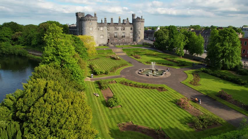 Ireland - july.27.2023 - excellent aerial footage circling tourists walking the grounds of kilkenny castle in kilkenny, ireland.