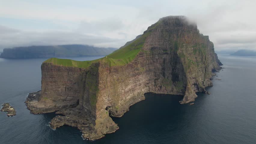 Faroe islands - july.16.2023 - excellent distant aerial view approaching a cliffside lighthouse in kalsoy of the faroe islands. | Shutterstock HD Video #1110477195