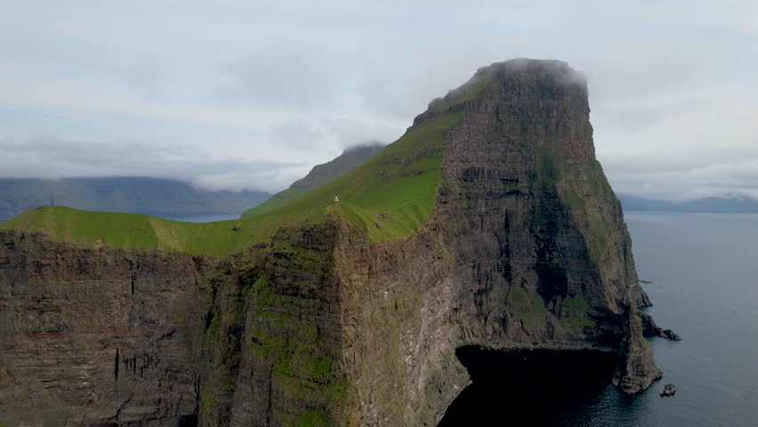 Faroe islands - july.16.2023 - excellent aerial footage moving towards a lighthouse on a cliff in kalsoy of the faroe islands. | Shutterstock HD Video #1110477203