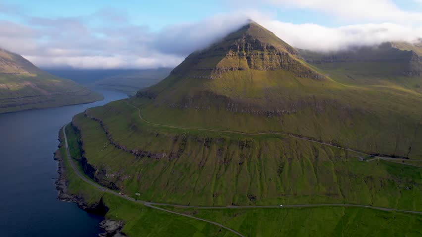 Faroe islands - july.16.2023 - excellent aerial footage of mist circling the top of a coastal mountain in funningur of the faroe islands. | Shutterstock HD Video #1110477211
