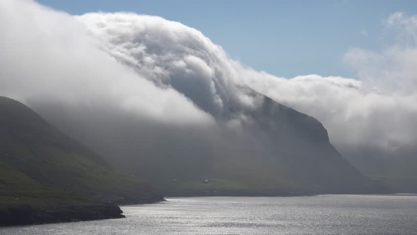 Faroe islands - july.16.2023 - time lapse of fog rolling over the mountains towards the sea in the faroe islands. | Shutterstock HD Video #1110477235