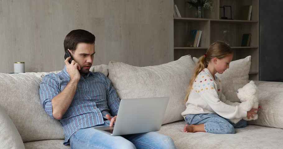 Focused father remote working businessman use laptop talk on phone while small daughter sit close to him on sofa play quiet game with teddy bear. Understanding little girl does not disturb dad at work Royalty-Free Stock Footage #1110482515