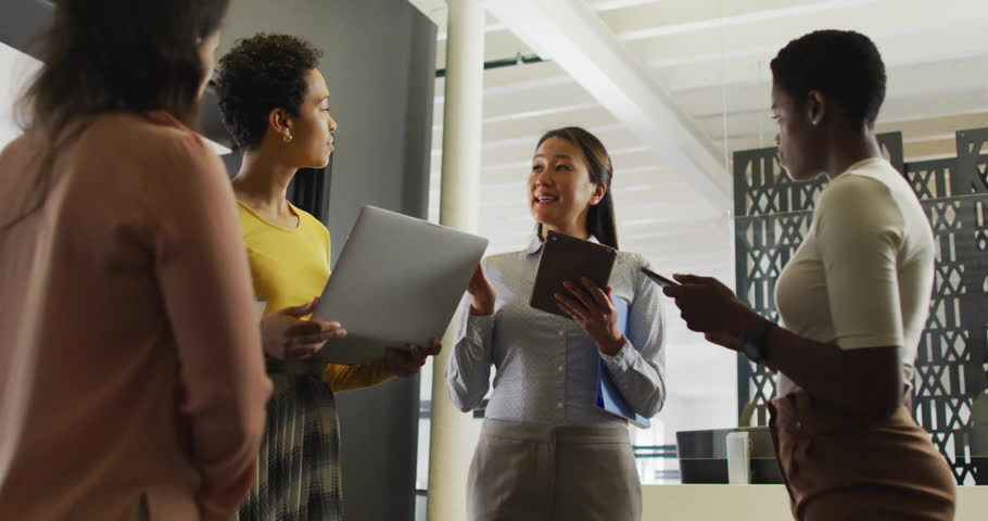 Animation of globe, graphs, loading bars and circles, diverse female coworkers discussing in office. Digital composite, multiple exposure, report, business, globalization, teamwork and technology.