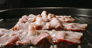 Frying halal beef bacon in pan side view close up slow motion. Halal alternative rich and smoky taste of beef bacon true treat. Crispy beef bacon ad advertising. Fried to perfect. Junk food