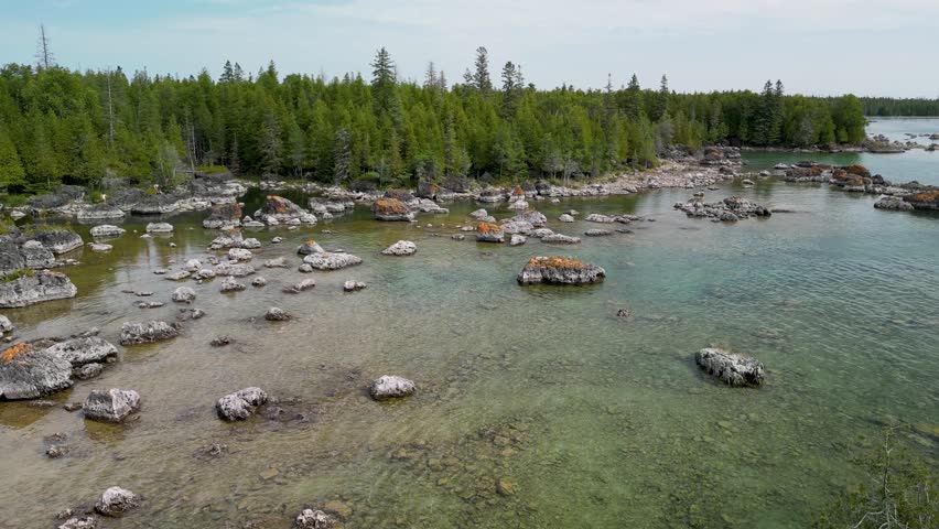 Aerial ascent of Bush Bay Wilderness forested rocky beach on lake huron, Michigan