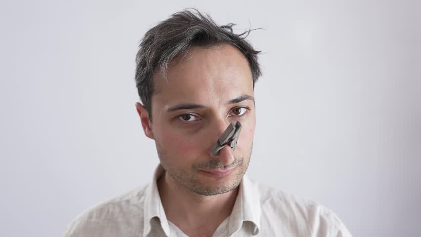Man with a clothespin on his nose