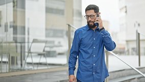 Young hispanic man business worker talking on smartphone sitting on stairs stressed at street - Powered by Shutterstock - Get 15% off with code: PIKWIZARD15